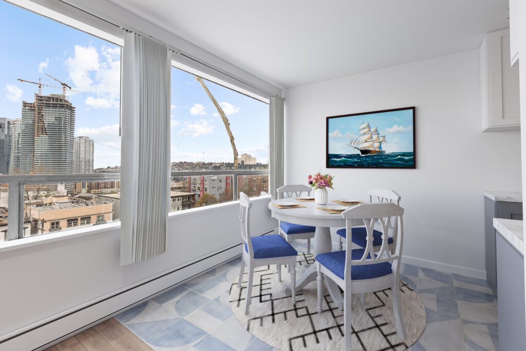 Bright Modern Dining Area With City Skyline View, Featuring a Round White Table With Blue Chairs and a Large Ship Painting on the Wall in an Apartment.